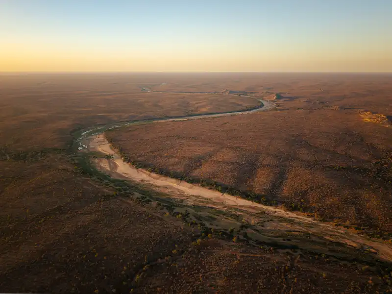 Aerial view of a winding river in the safari landscape at sunset